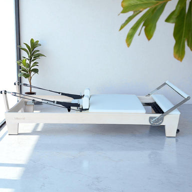 Full Side View of Milaron Maple Studio Reformer with creme carriage and frame