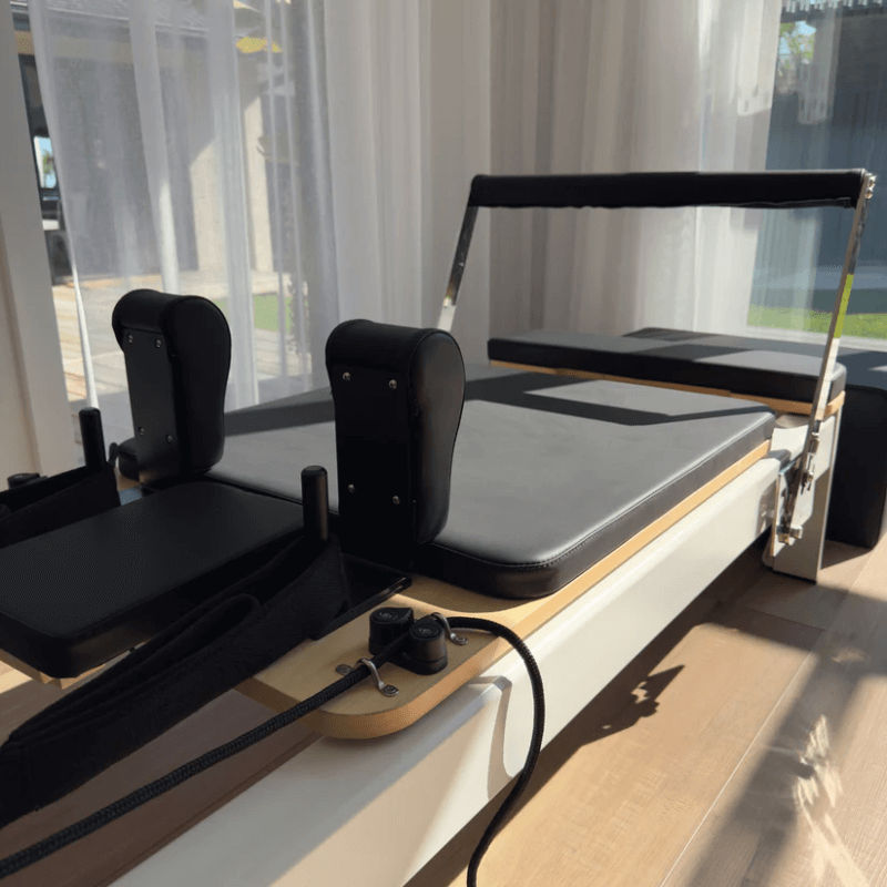 Close up of carriage and footbar on Milaron Pearl Reformer in black with white frame