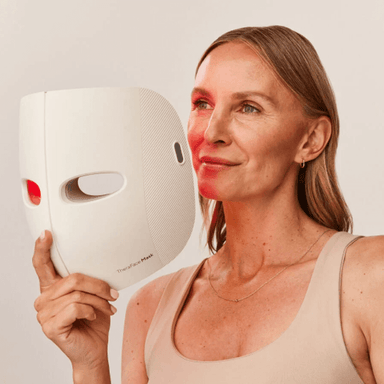 Lady holding up and about to use the white Theraface Mask