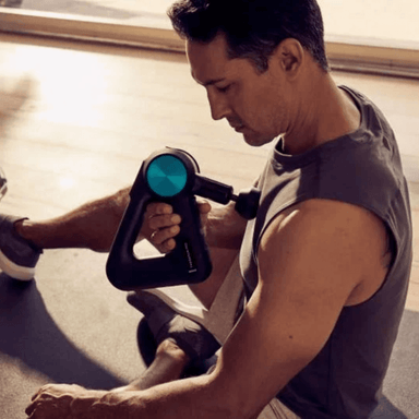 In situ image of seated male athlete using the Theragun 5th Generation on his chest