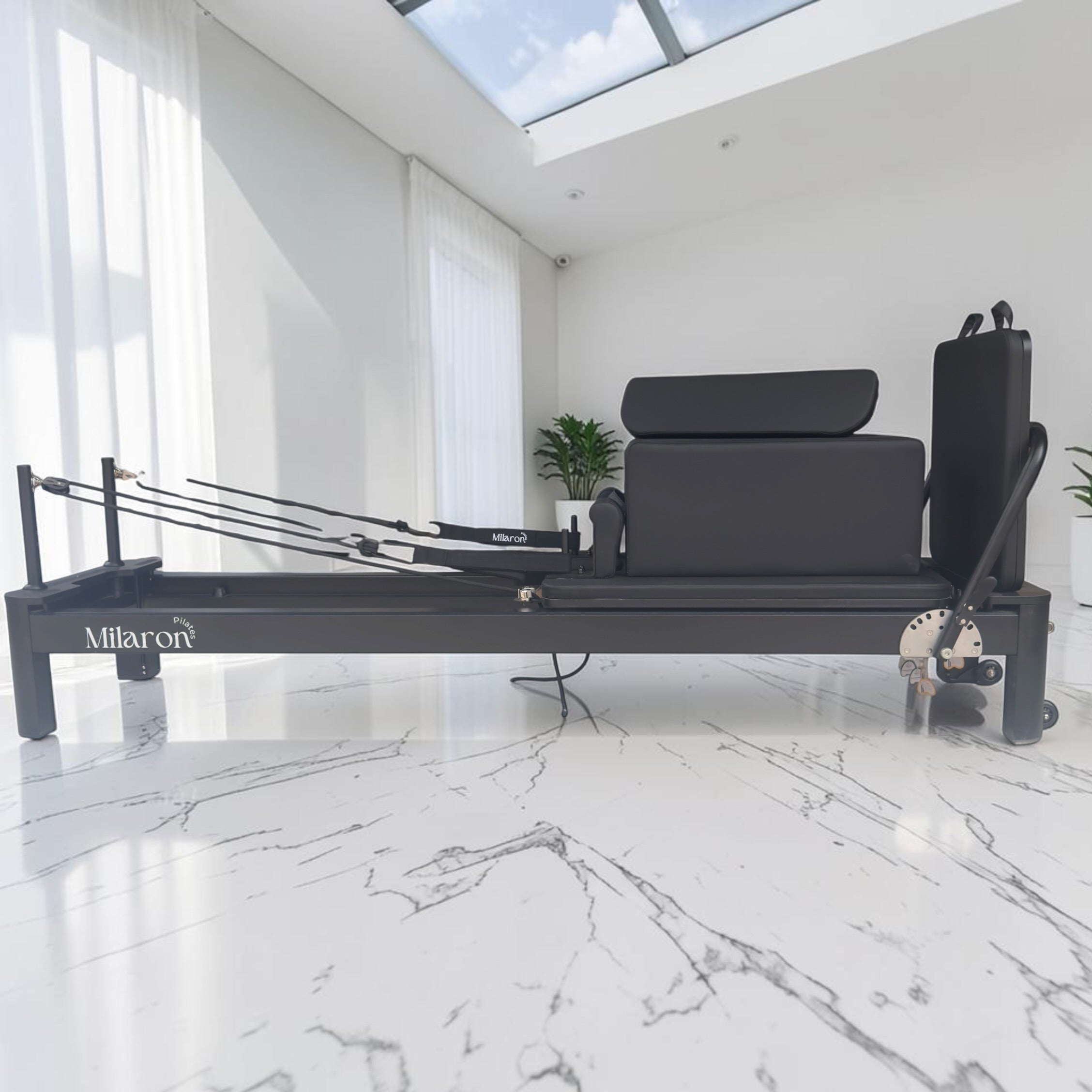 Milaron Pearl V3 studio Pilates reformer in Noir, black aluminium frame with matching carriage upholstery, viewed from the front