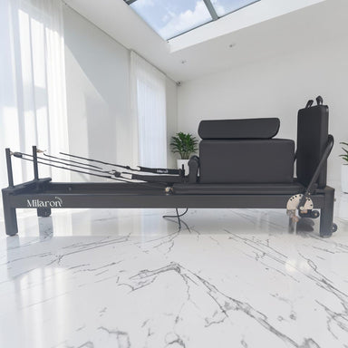 Milaron Pearl V3 studio Pilates reformer in Noir, black aluminium frame with matching carriage upholstery, viewed from the front