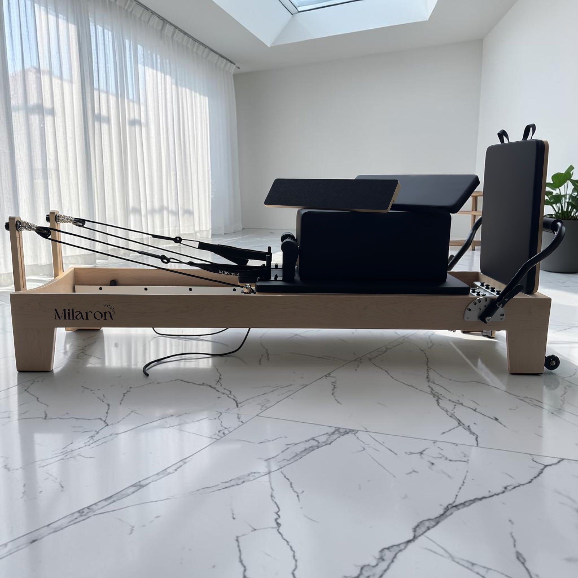 Side profile of the Milaron Maple Studio V3 reformer showing the full carriage and spring platform