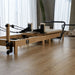 Core Collab Wooden Foldable Reformer in Beige in studio setting 