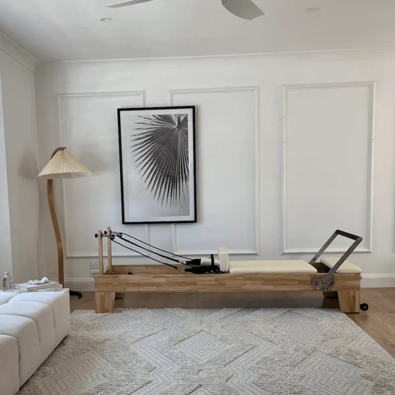 Full Side View of Wooden Reformer with Beige carriage in home living room setting