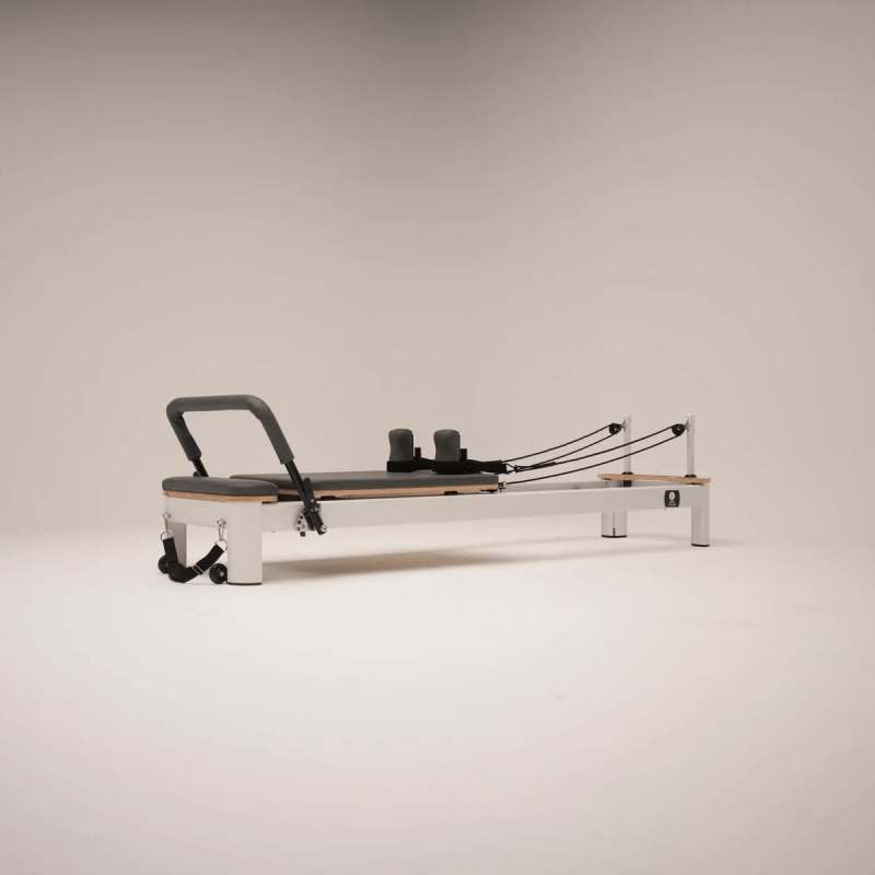 Studio Style Flatlay image of Core Collab Queen Reformer with White Frame and Grey Upholstery with white background
