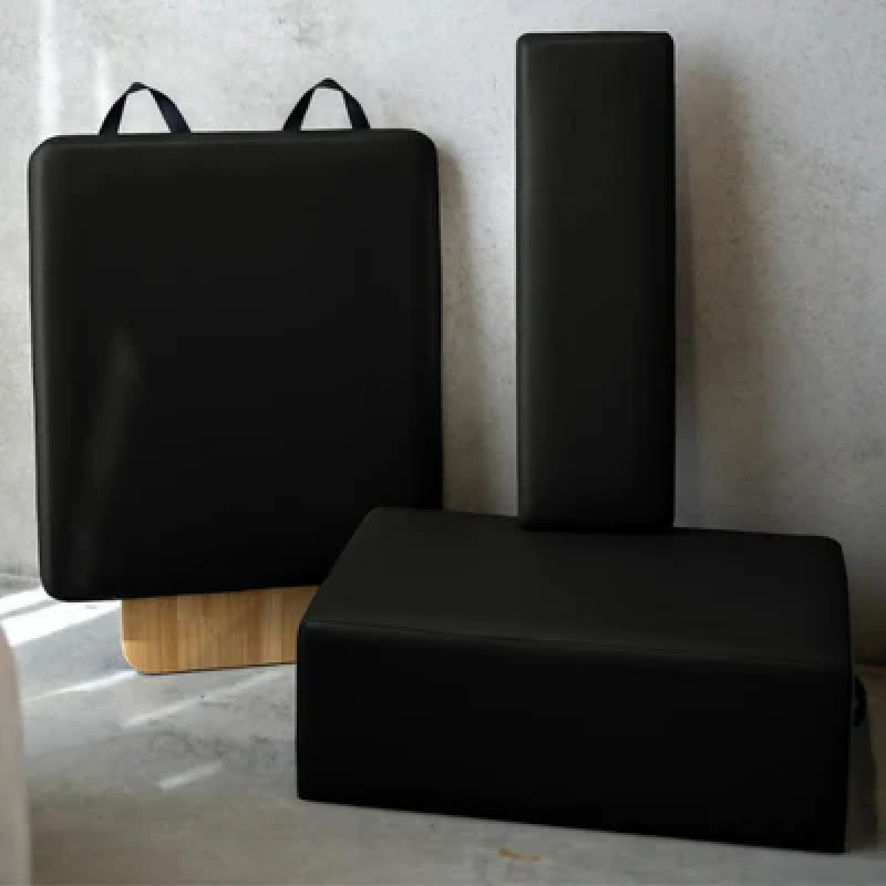 Flatlay style image of reformer accessories in black with grey background