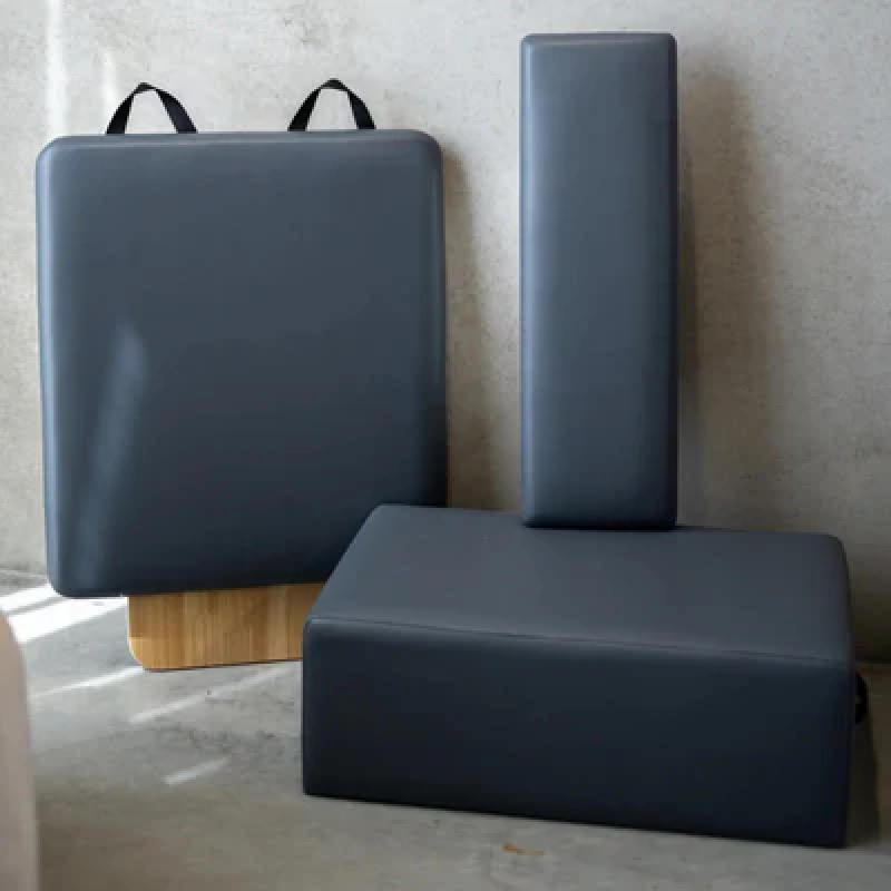 Flatlay style image of reformer accessories in grey with grey background