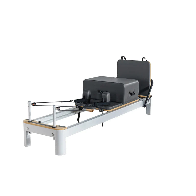 Flatlay image of Core Collab Queen Studio in grey on white showing full view of reformer at front side angle with accessories attached