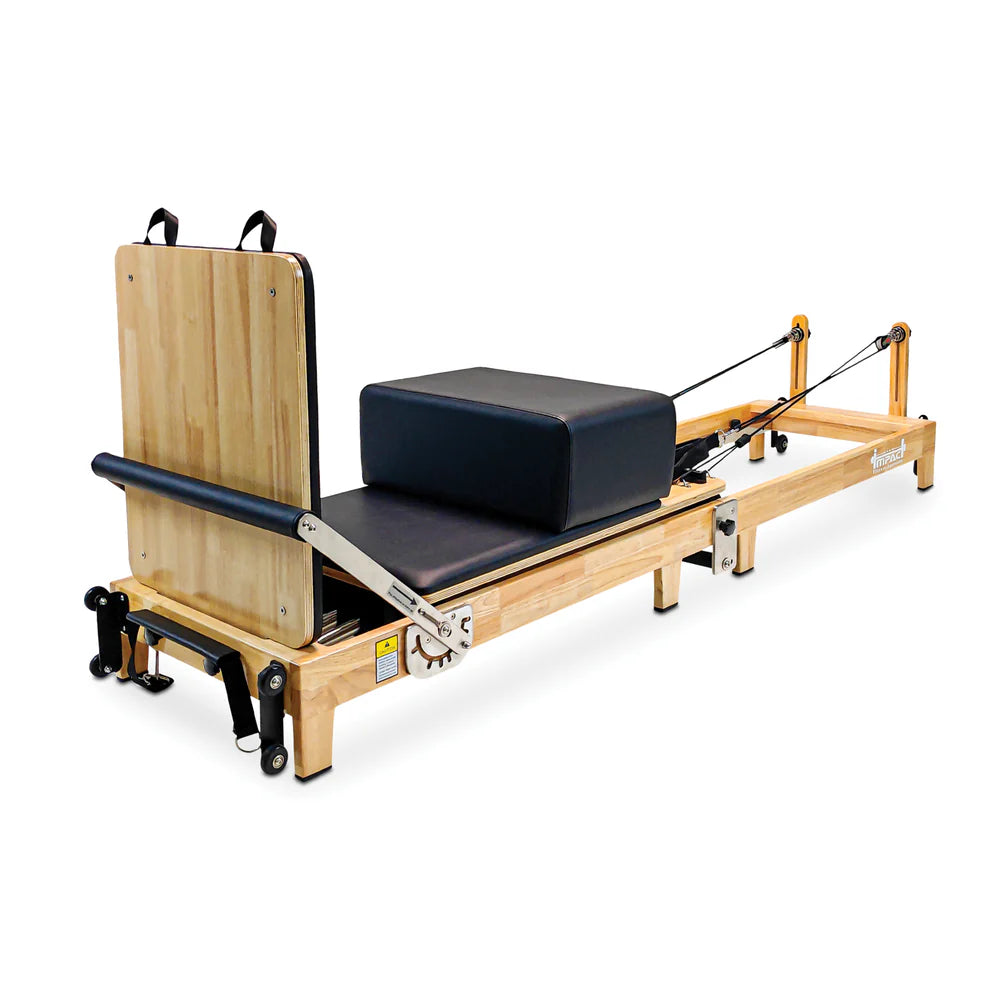 Full Angle Side View of the Impact Fitness Foldable Pilates reformer with black carriage and oak frame showing back view of jumpboard