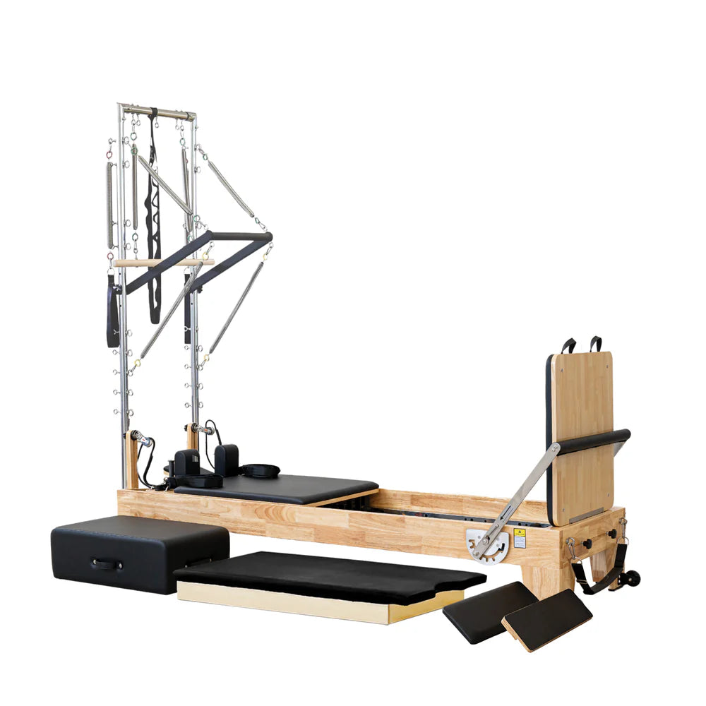 Angled Front View of Impact Fitness Pilates Reformer Machine in Oakwood with Half Trapeze showing Trapeze Springs and bars and extra accessories