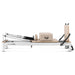 Side view of beige and white pilates reformer on white background