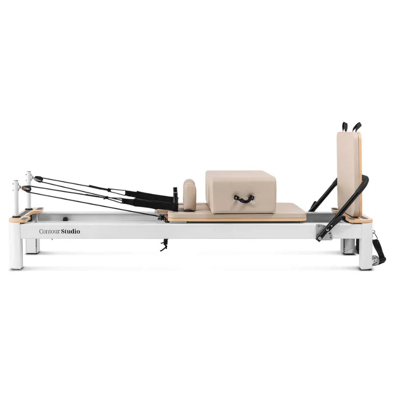 Side view of beige and white pilates reformer on white background