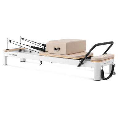 Side view of pilates reformer on white background with sitting box and footbar up