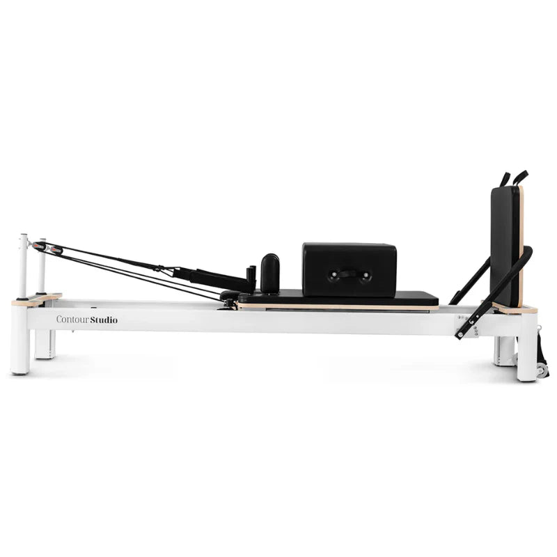 Direct side view of whie pilates reformer with black leather on white background