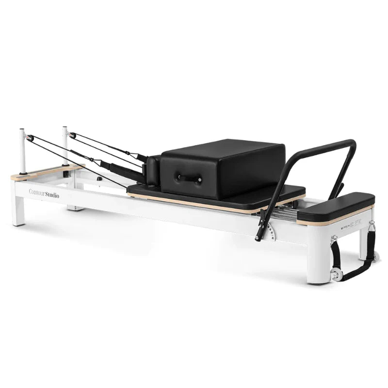 Side view pilates reformer with white frame and black upholstery with footbar up