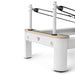 Close up on pulley riser poles on pilates reformer machine in white