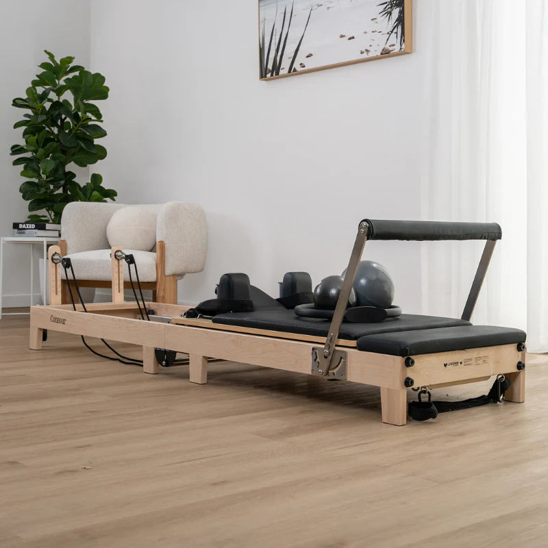 Angle Full Side View of Lifespan Fitness Wooden Pilates Reformer in black in home on wooden floor boards