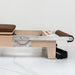 Close up wooden pilates reformer machine with footbar lowered on white background