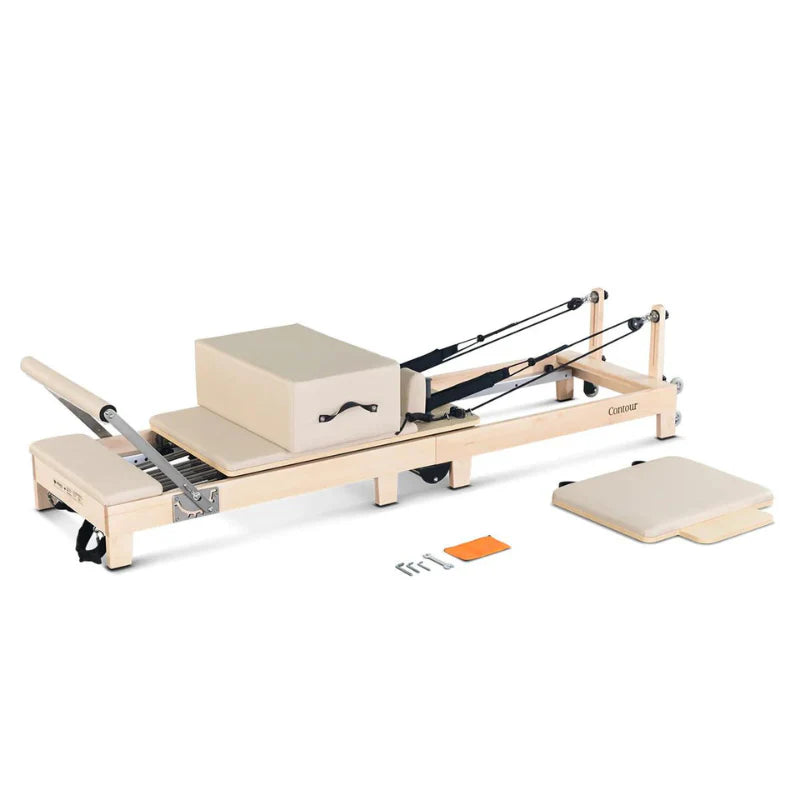 Full Side View Lifespan Fitness Wooden Contour Pilates Reformer with Sitting box on bed and jumpboard and tools on floor
