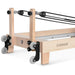 Close up of wheels and pulley risers of wooden pilates reformer