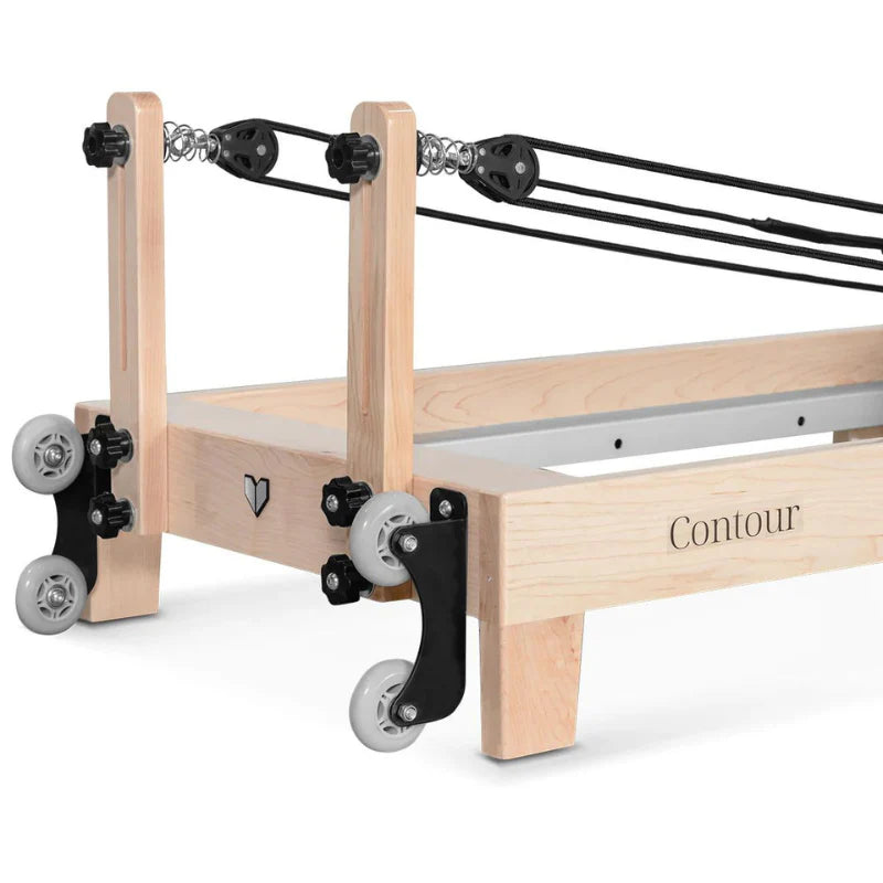 Close up of wheels and pulley risers of wooden pilates reformer