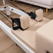 Close up of shoulder rest and head rest on beige pilates reformer on wooden floor