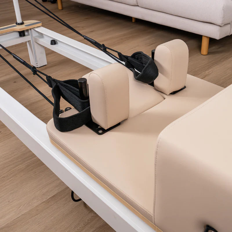 Close up of shoulder rest and head rest on beige pilates reformer on wooden floor