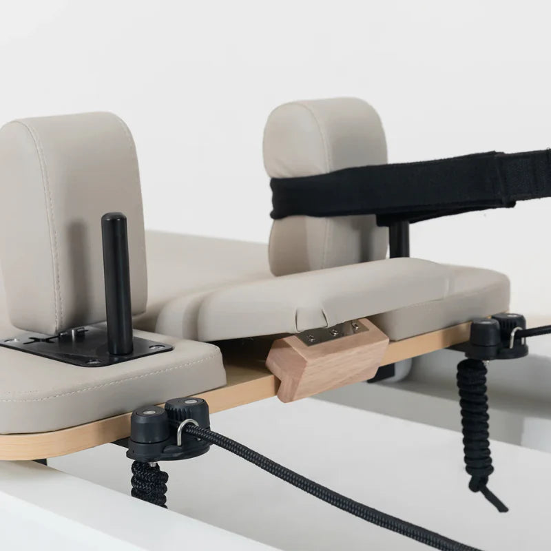 Full Close up of shoulder pads and straps on pilates reformer machine with beige leather