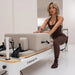 Woman doing lunges on beige and white aluminium reformer