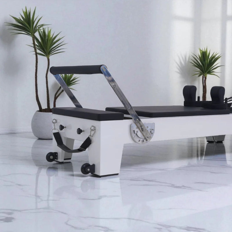 Milaron Blanc White Pilates reformer with black upholstery in a room with plants white marble floors.