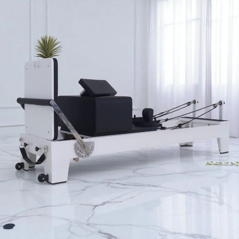 Milaron Blanc Pilates reformer machine in a white room with marble floor with accessories on top of carriage