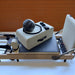 Close up view of Milaron Maple FOldable reformer in creme with jumpboard attached and sitting box and accessories sitting on carriage with protective carriage matt.