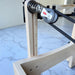 Extreme close up of riser and pulley system on Milaron Maple Foldable reformer showing wooden frame in oak with black rope straps