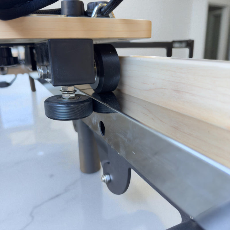 Extreme close up of under the carriage to show glide system in place for the Milaron Maple Foldable reformer