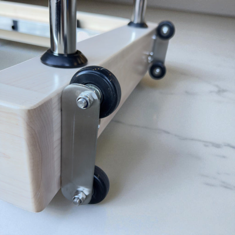 Close up of wheels at the ends of the Milaron Maple Foldable reformer. 