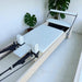 Angled aerial view of Carriage for Milaron Maple Studio Reformer with creme carriage and frame.  Footbar is up