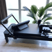 Side view close up of pilates reforem with black carriage with footboard on carriage