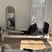 Full side view of Milaron Pearl Reformer at home with sitting board resting on carriage and jumpboard attached