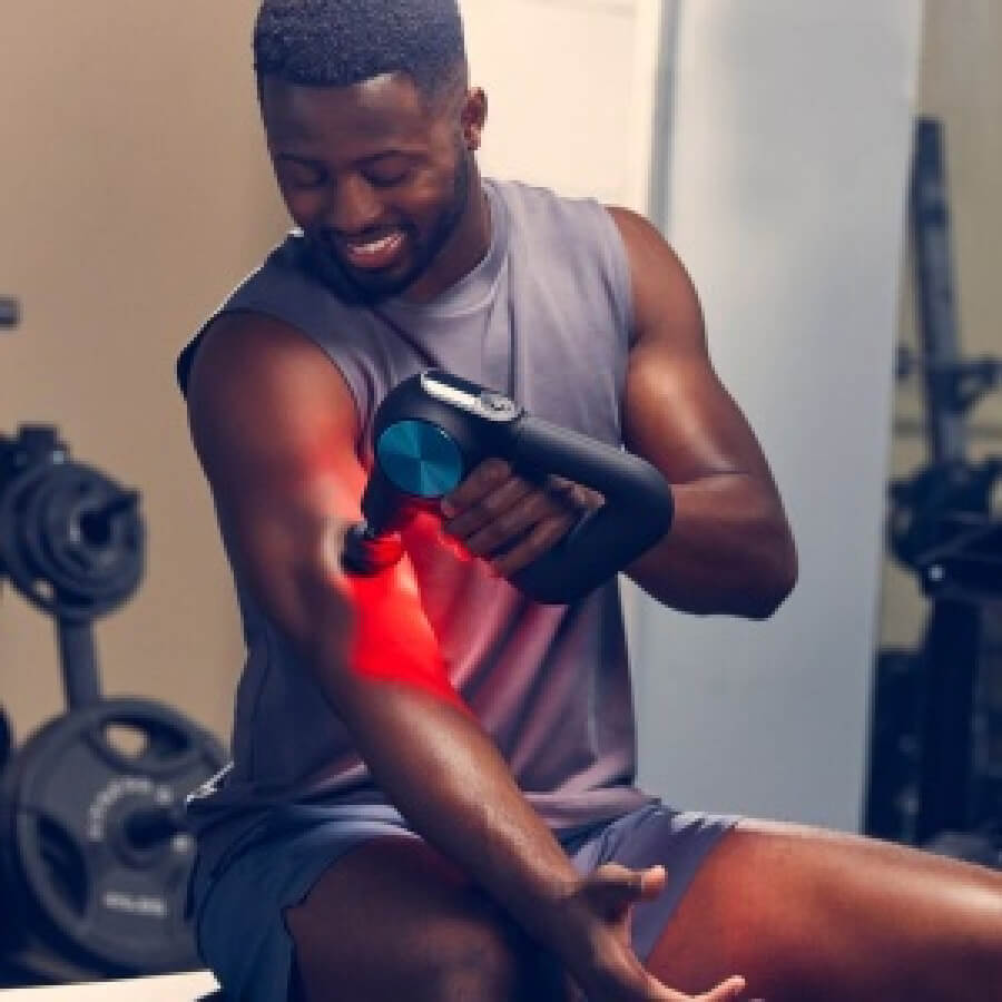 Image of male at the gym using Theragun Pro Plus to massage biceps