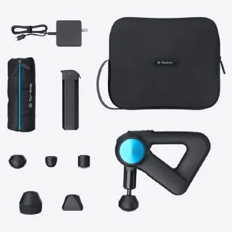 Flat lay image showing side view of black Theragun 5th Generation massage gun as well as 5 attachments, carry bag and charging cord
